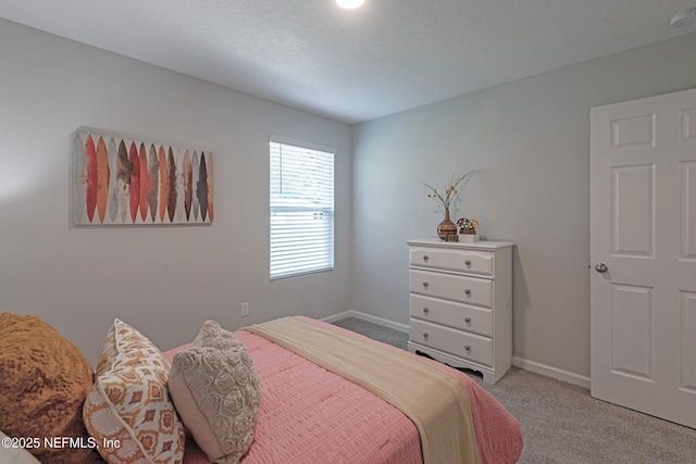 bedroom with light colored carpet and a textured ceiling