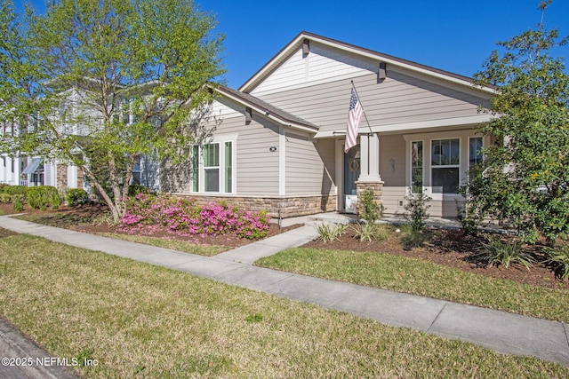 view of front of home featuring stone siding and a front lawn