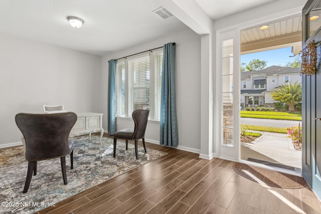 sitting room with baseboards, visible vents, and wood finish floors