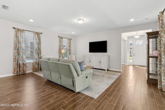 living area with baseboards, wood tiled floor, visible vents, and recessed lighting
