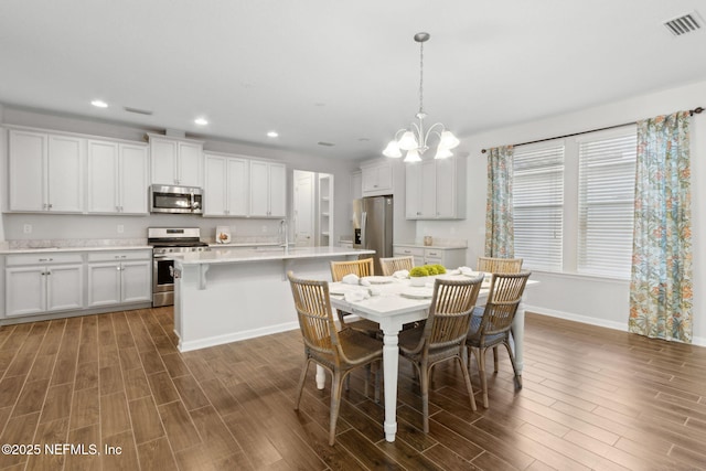 dining area with visible vents, wood tiled floor, an inviting chandelier, and recessed lighting