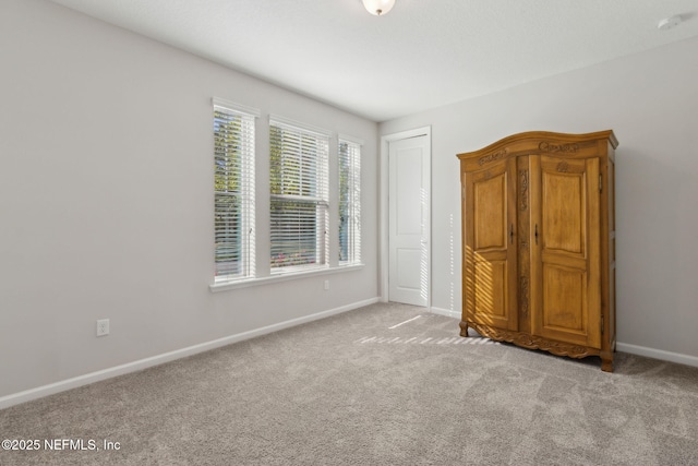 unfurnished bedroom with baseboards, a closet, and carpet