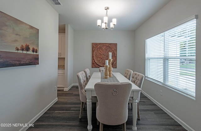 dining space with dark wood-type flooring and a chandelier