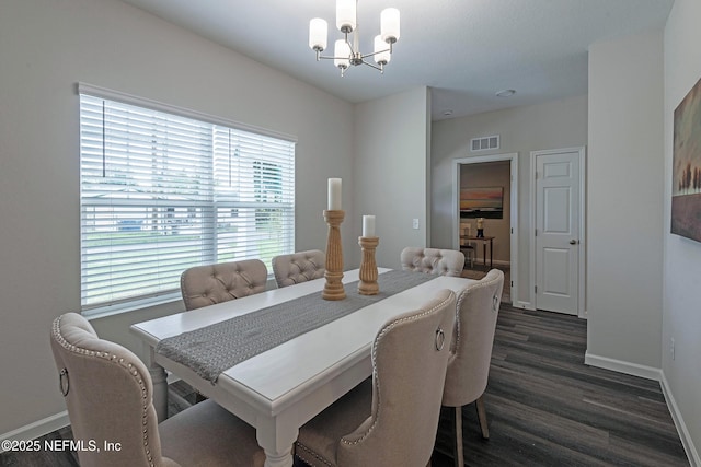 dining space with dark wood-type flooring and a notable chandelier