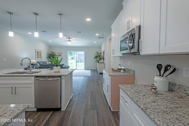 kitchen with sink, ceiling fan, light stone countertops, white cabinetry, and stainless steel appliances