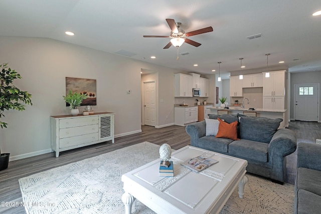 living room featuring dark hardwood / wood-style floors, ceiling fan, lofted ceiling, and sink