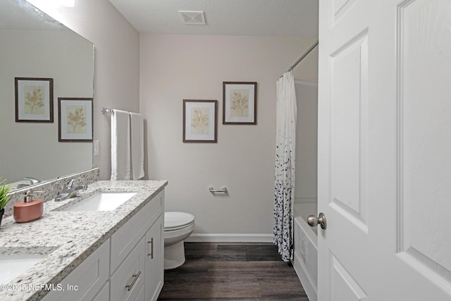 full bathroom featuring shower / bath combo, vanity, a textured ceiling, wood-type flooring, and toilet