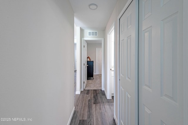 hallway with dark hardwood / wood-style flooring