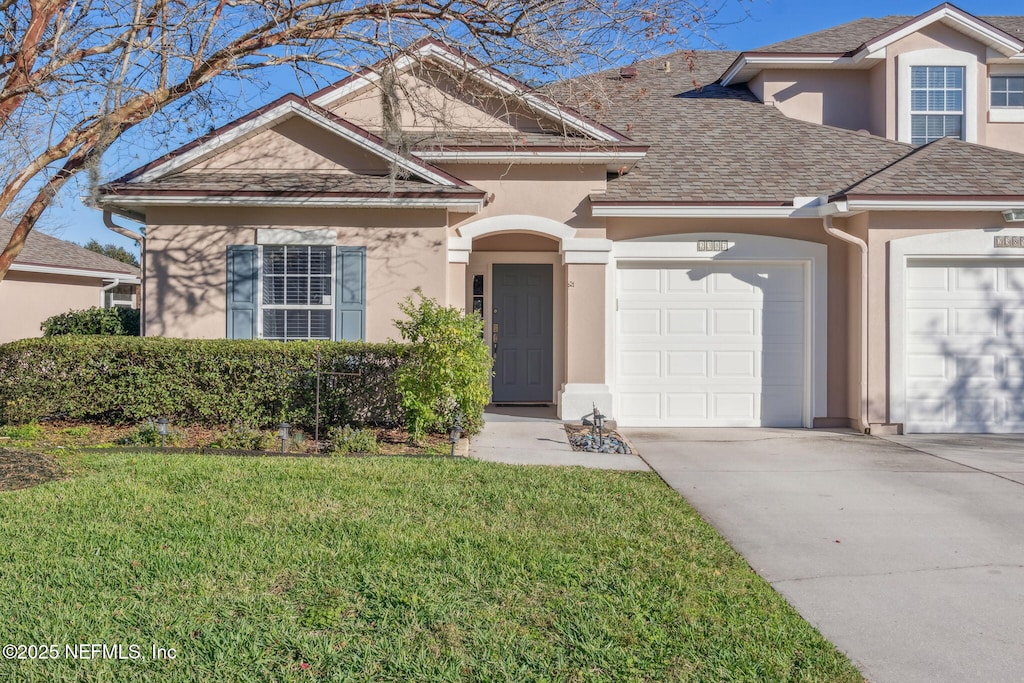 view of front of property featuring a front yard and a garage