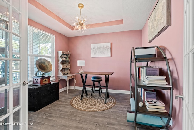 office with a tray ceiling and a chandelier