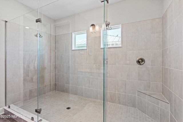 bathroom featuring an inviting chandelier and a shower with door