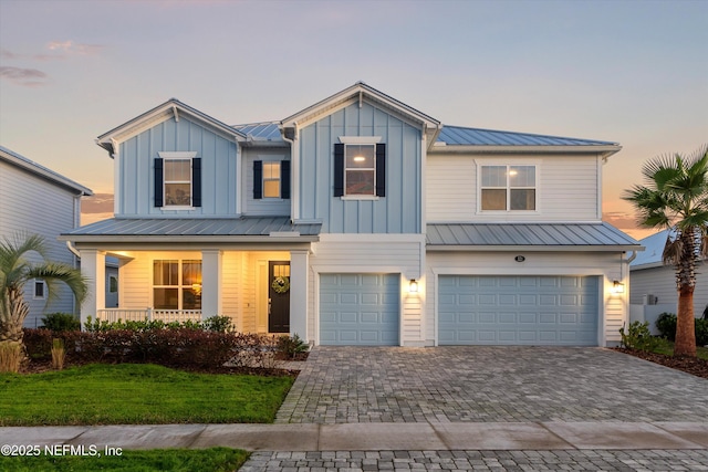 321 Marquesa Cir, Saint Johns, FL 32259 - view of front of house featuring an attached garage, driveway, covered porch, metal roof, and board and batten siding