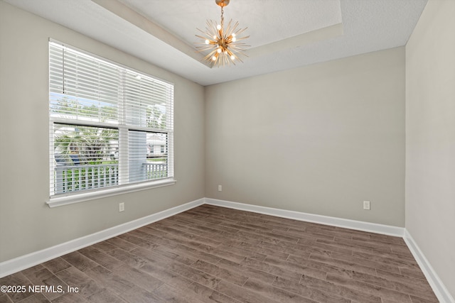 321 Marquesa Cir, Saint Johns, FL 32259 - spare room with a chandelier, dark wood-style flooring, baseboards, and a raised ceiling