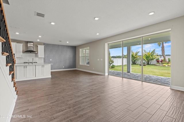 321 Marquesa Cir, Saint Johns, FL 32259 - unfurnished living room featuring baseboards, light wood finished floors, stairs, recessed lighting, and a sink
