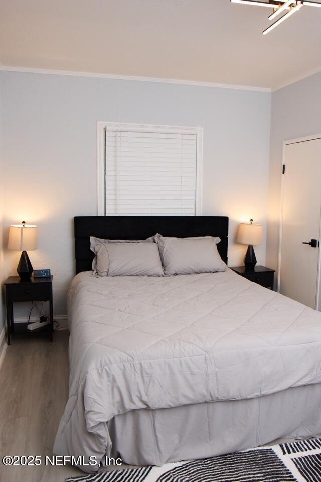 bedroom featuring hardwood / wood-style flooring and crown molding