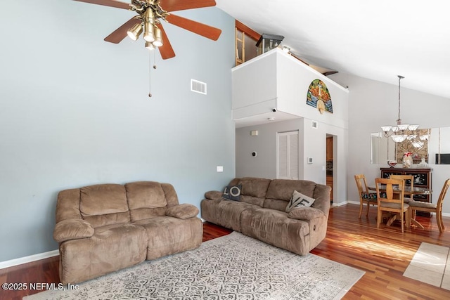 living room featuring high vaulted ceiling, ceiling fan with notable chandelier, and hardwood / wood-style flooring