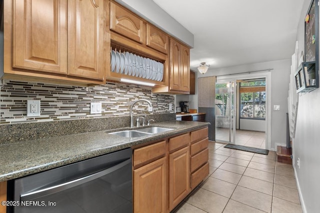 kitchen featuring light tile patterned floors, black dishwasher, tasteful backsplash, dark stone counters, and sink