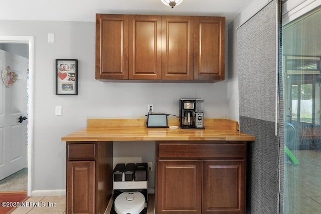 bar featuring wooden counters and light tile patterned flooring