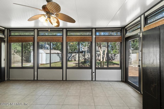 unfurnished sunroom featuring ceiling fan