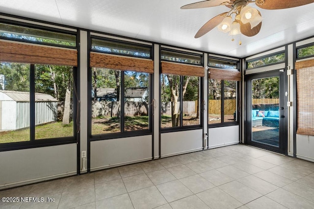 unfurnished sunroom with ceiling fan