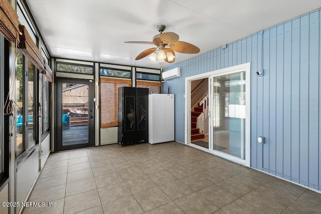 unfurnished room featuring ceiling fan, tile patterned floors, and a wall mounted air conditioner