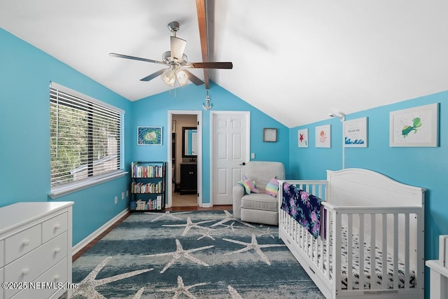 bedroom featuring ceiling fan, vaulted ceiling with beams, and a crib