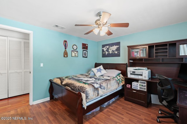 bedroom with ceiling fan, a closet, and dark wood-type flooring