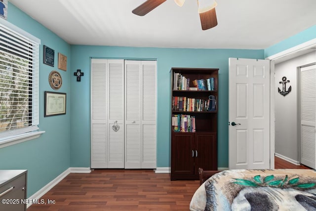 bedroom with ceiling fan, dark wood-type flooring, and a closet