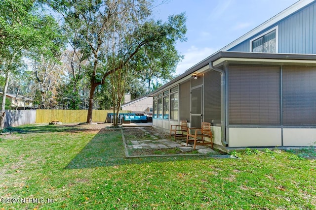 view of yard with a sunroom and a patio