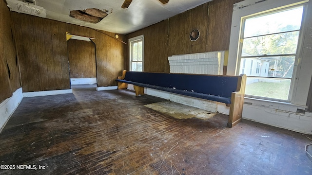 interior space with ceiling fan and wood walls