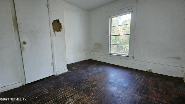 unfurnished room with dark hardwood / wood-style flooring