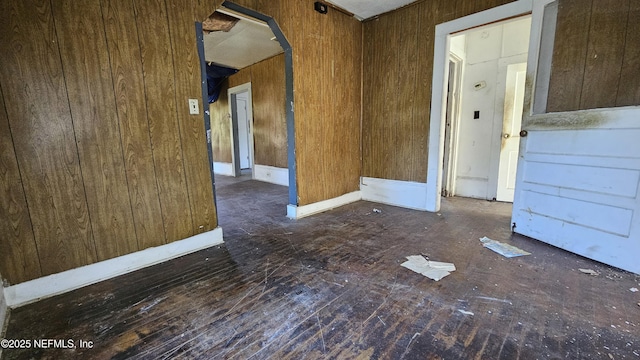 empty room featuring wood walls