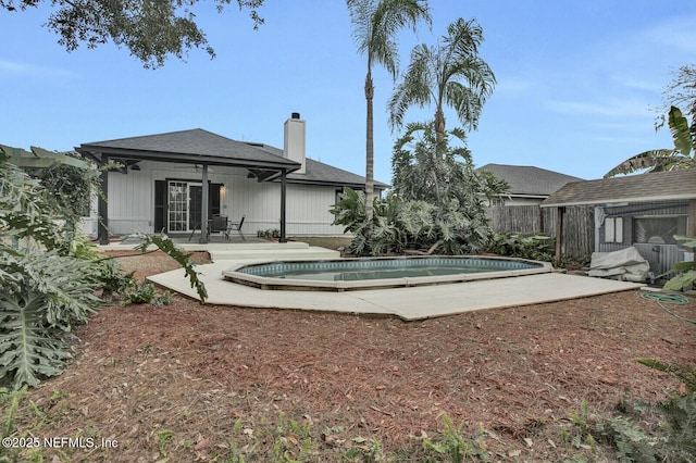 back of house featuring a fenced in pool and a patio