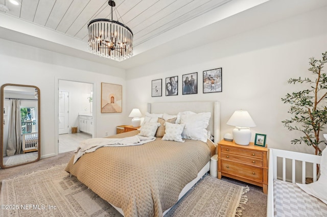 bedroom featuring wooden ceiling, carpet flooring, ensuite bathroom, and a notable chandelier