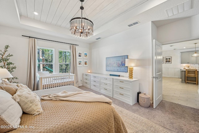 bedroom featuring a raised ceiling and an inviting chandelier