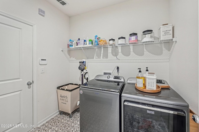 washroom with washer and clothes dryer and light tile patterned floors