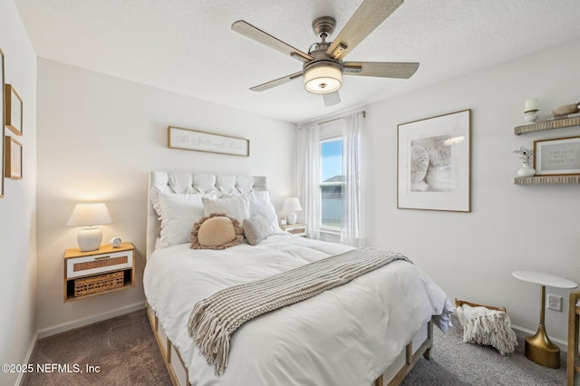 bedroom with a textured ceiling, dark carpet, and ceiling fan