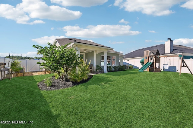 view of yard with ceiling fan and a playground