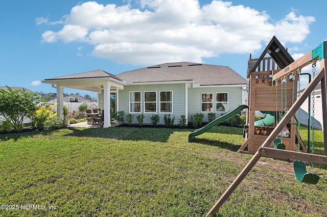 back of house featuring a playground and a lawn