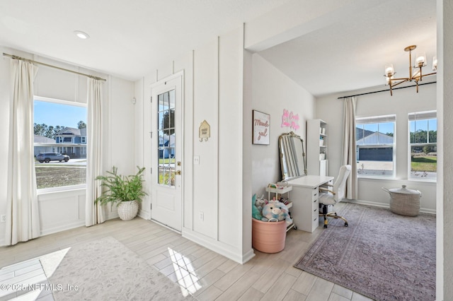 foyer entrance featuring a chandelier and a wealth of natural light