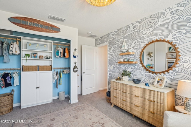 carpeted bedroom with a textured ceiling and a closet