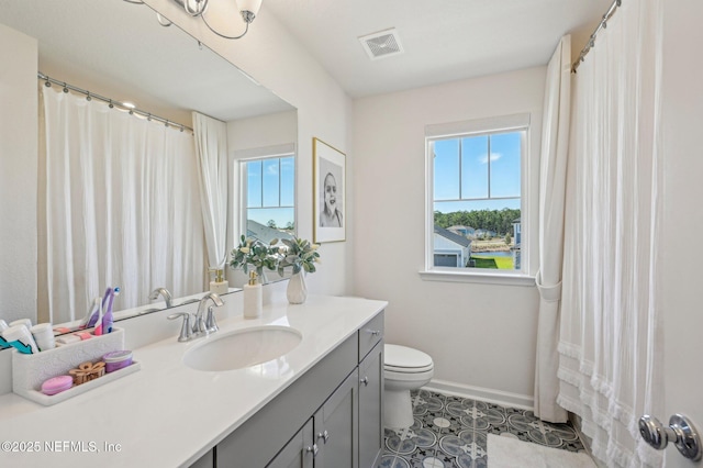 bathroom with vanity, toilet, and plenty of natural light