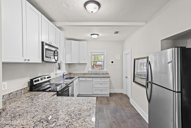 kitchen with white cabinets, sink, a textured ceiling, dark hardwood / wood-style flooring, and stainless steel appliances