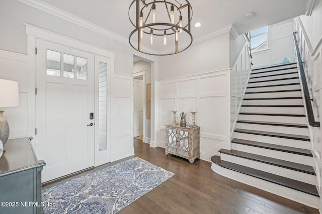 entryway featuring dark hardwood / wood-style flooring, ornamental molding, and a chandelier