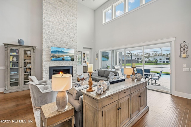 living room featuring a fireplace, hardwood / wood-style floors, and a high ceiling