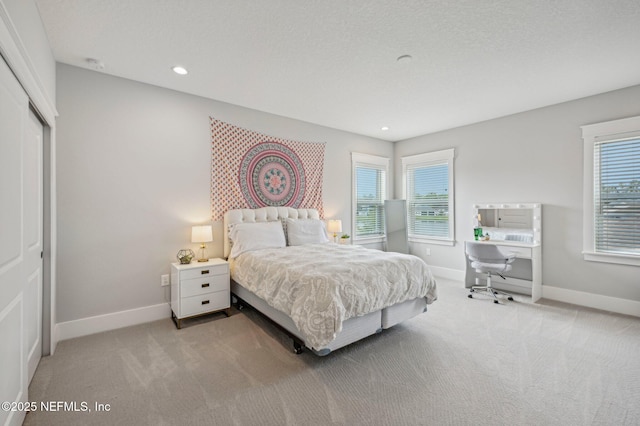 bedroom featuring a closet, light carpet, and multiple windows