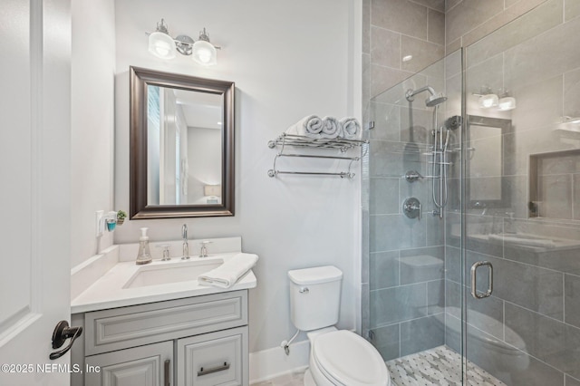 bathroom featuring toilet, an enclosed shower, and vanity