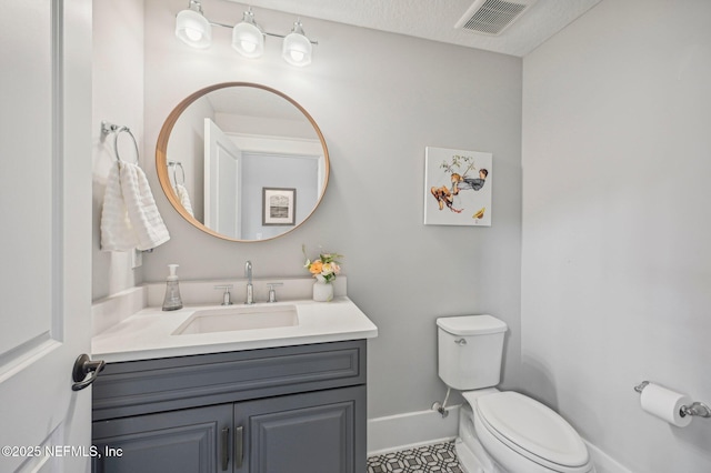 bathroom with vanity, a textured ceiling, and toilet