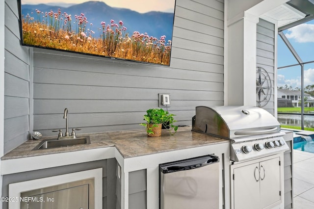 view of patio / terrace with an outdoor kitchen, a water view, grilling area, and sink