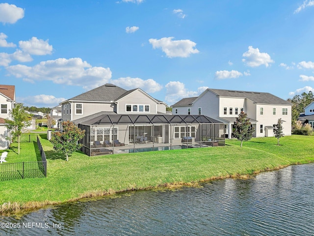 back of property with a lanai, a yard, and a water view